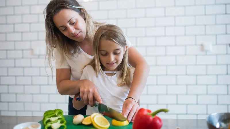 Çocukluk çağı obezitesinde beslenme için ailesiyle dengeli akşam yemeği hazırlayan çocuk